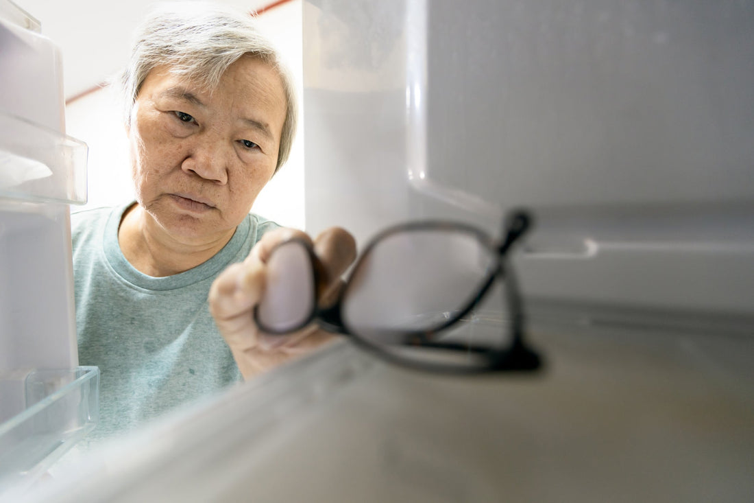 Older woman finding a misplaced pair of glasses inside a refrigerator